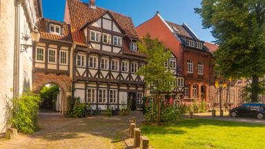 polen_baltische-staten_duitsland_nedersaksen_braunschweig_brunswijk_vakwerkhuis_poort_straat_klinker_paaltje_gras_boom_auto_zon_getty