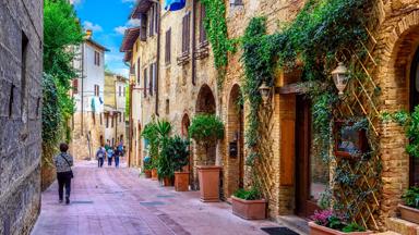 italie_toscane_san-gimignano_straatje_vrouw_huizen__shutterstock_1078952924