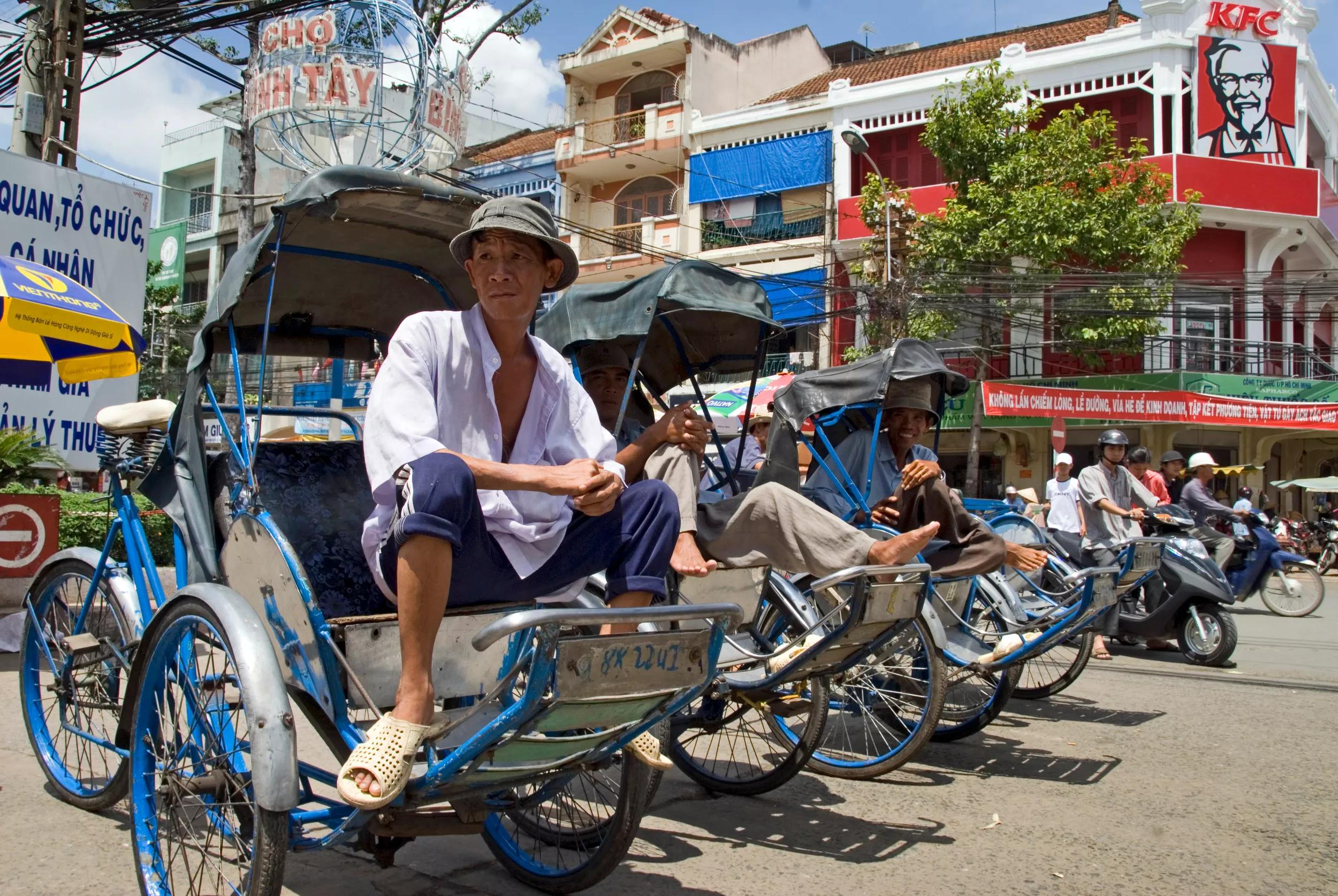 Ho Chi Minh City, Vietnam, October 2008. Cyclo taxi's wait for a fare in front of he Chinese Bin Tay wholesale market and the KFC, kentucky Fried Chicken in Cholon.  Photo by Frits Meyst/Adventure4ever.com